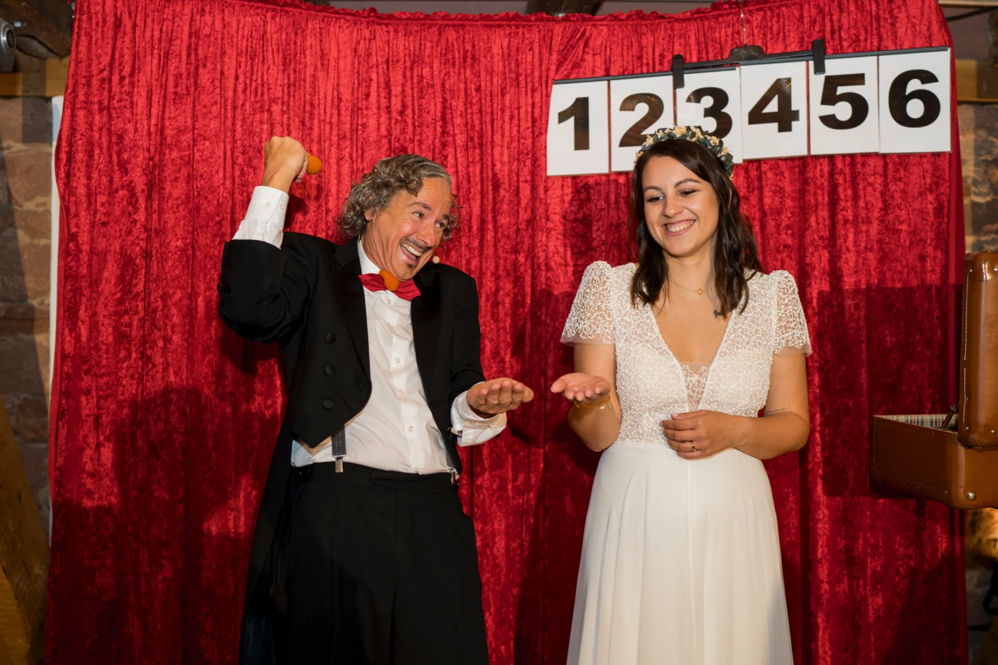 Sabrina und Tobias posieren vor dem roten Vorhang der Fotobox
